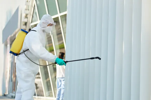 Pest Control Worker Spraying Out side the commercial area